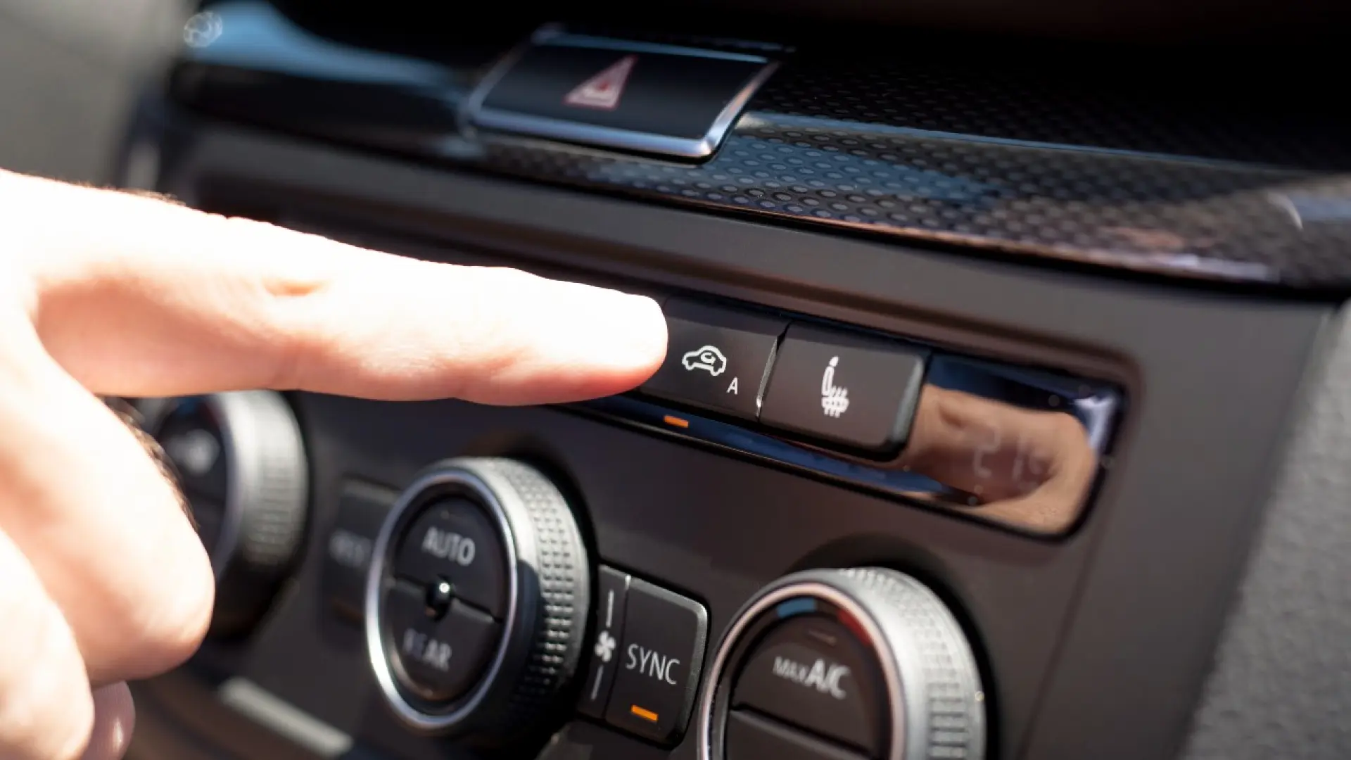 Gros plan sur les boutons de climatisation d'un tableau de bord automobile incluant le mode auto et recirculation d'air